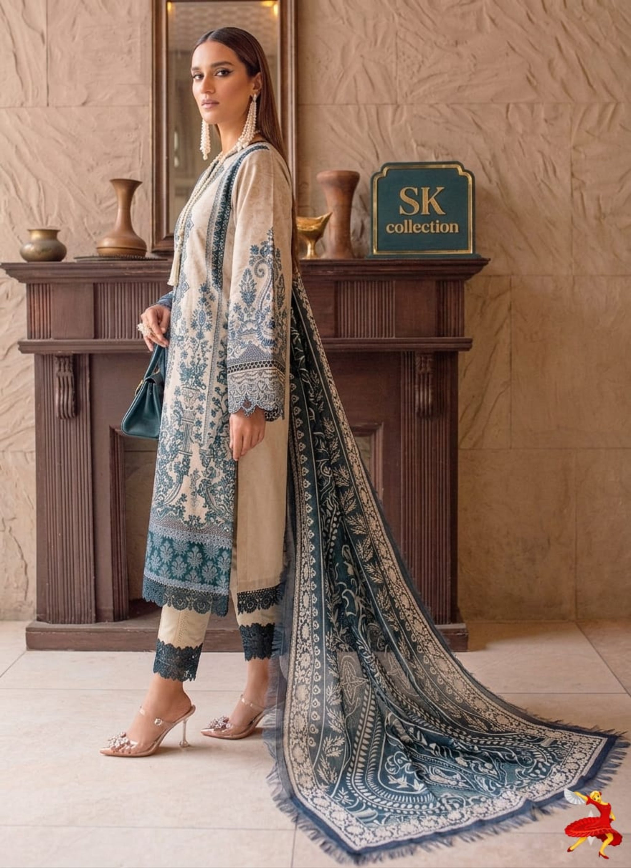 Woman in a traditional outfit with a long scarf, standing indoors against a decorative wall.